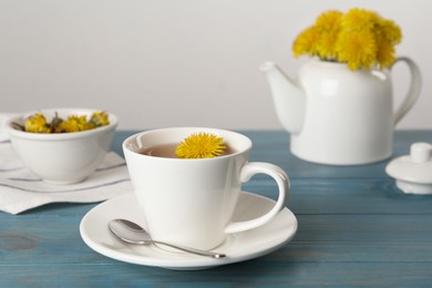Photo of Delicious fresh dandelion tea on light blue wooden table