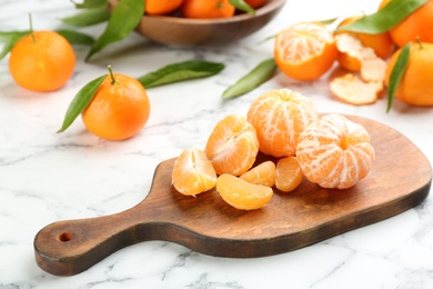 Fresh peeled tangerines on white marble table