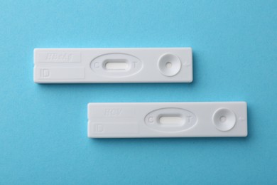 Photo of Disposable express tests on light blue background, top view