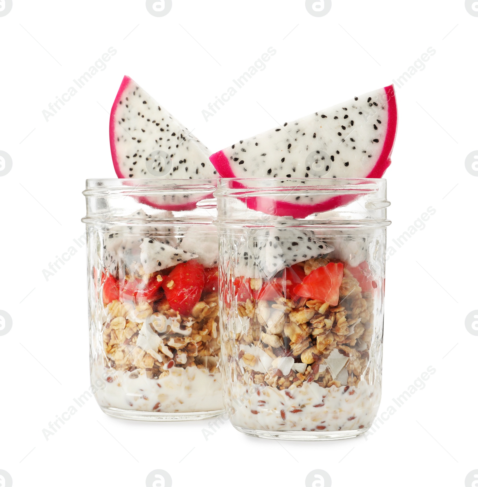 Photo of Granola with strawberries and pitahaya in glass jars on white background