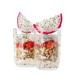 Granola with strawberries and pitahaya in glass jars on white background