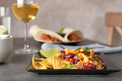 Plate with tasty chili con carne served on gray table