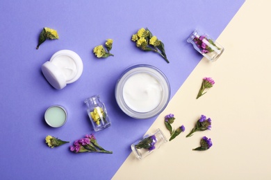 Photo of Flat lay composition with jars of body cream on color background