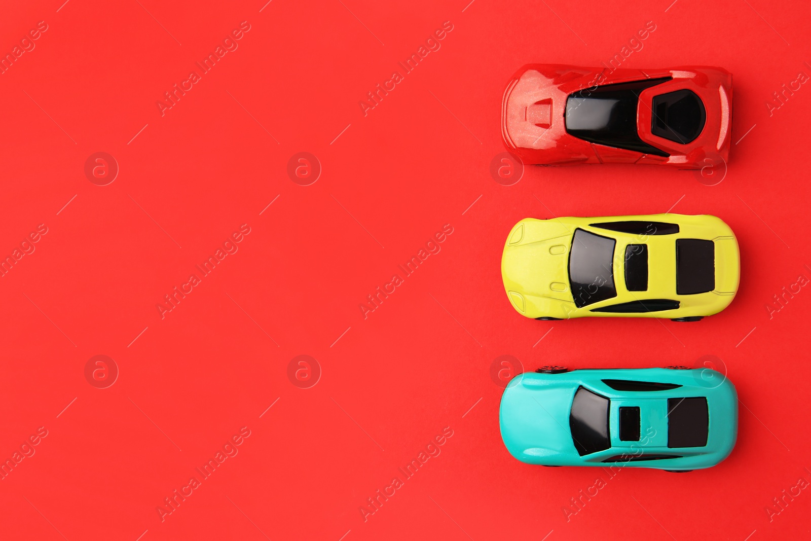 Photo of Different bright cars on red background, flat lay. Space for text