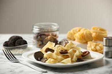 Photo of Tasty tagliatelle with truffle on white marble table