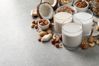 Vegan milk and different nuts on grey table