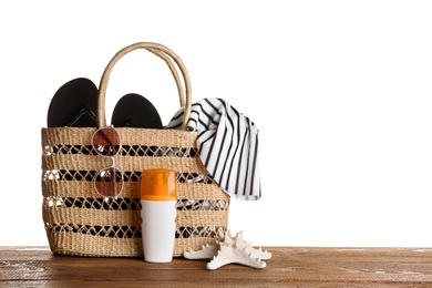 Set of beach accessories on wooden table, white background