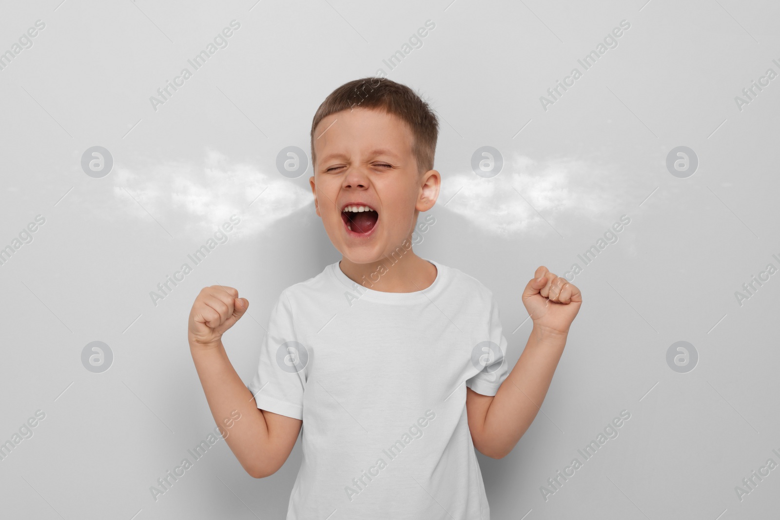 Image of Aggressive little boy with steam coming out of his ears on grey background