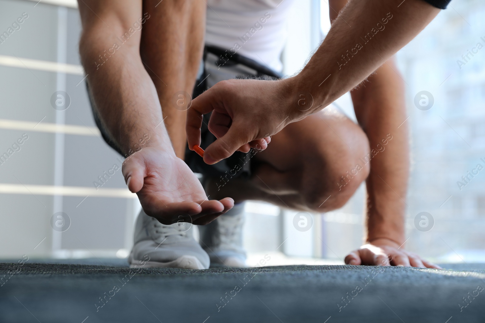 Photo of Sportsman receiving pill from dealer indoors, closeup. Doping concept