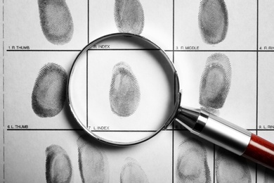 Photo of Criminal fingerprint card and magnifier, top view