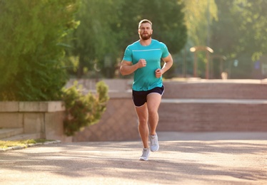Photo of Young man running in park on sunny day