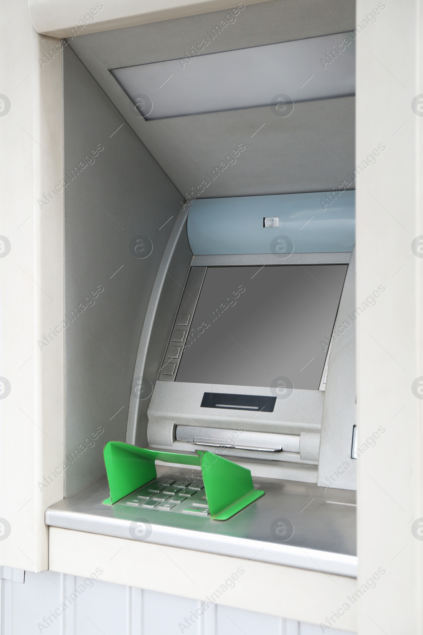 Photo of Modern automated cash machine with screen outdoors