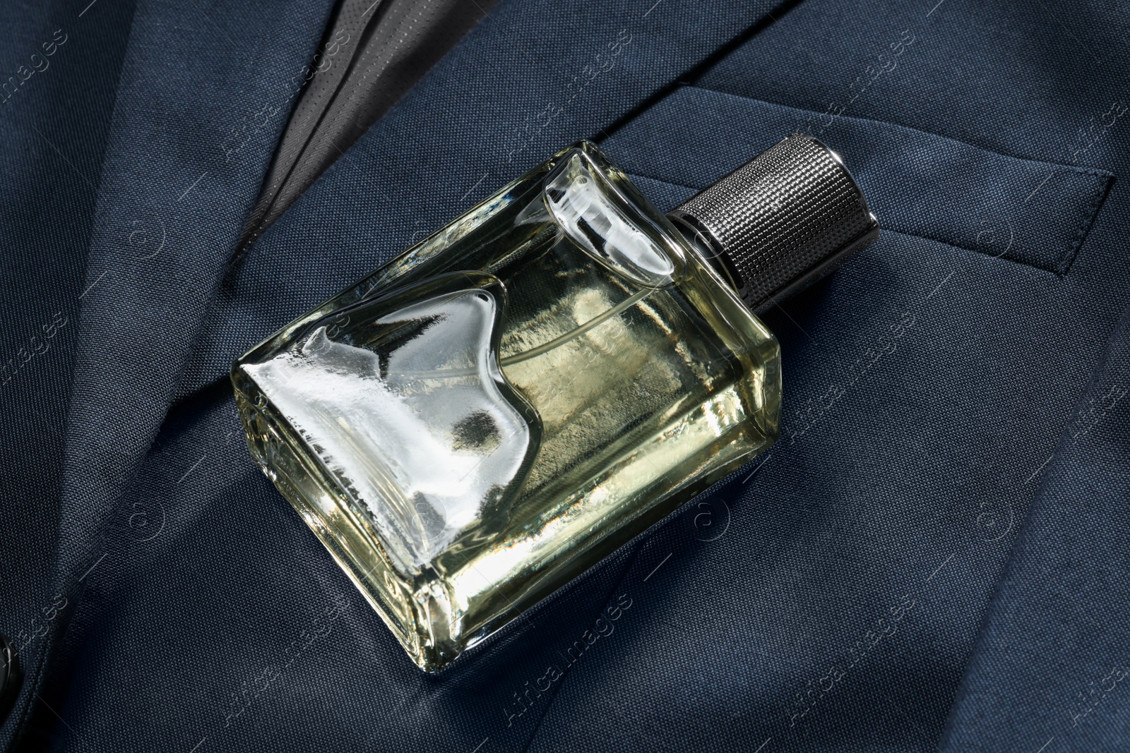 Photo of Luxury men's perfume in bottle on grey jacket