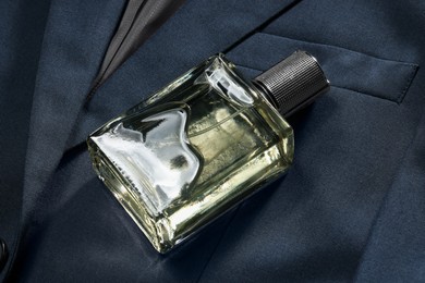 Photo of Luxury men's perfume in bottle on grey jacket