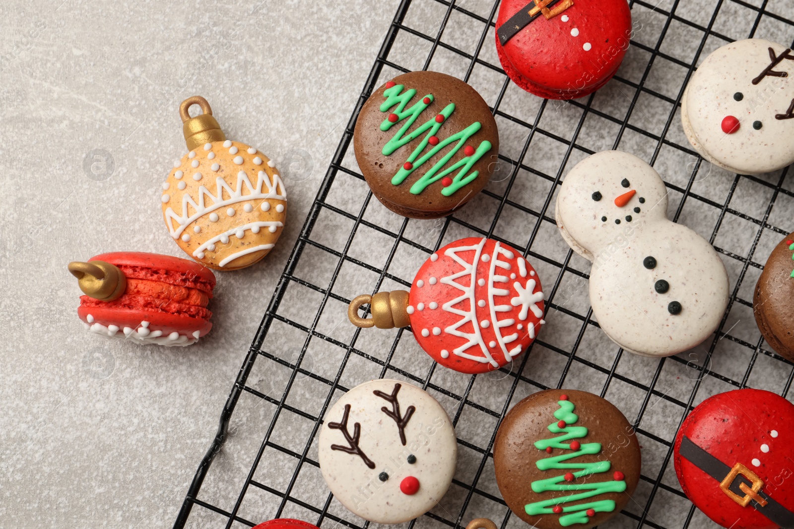 Photo of Beautifully decorated Christmas macarons on light grey table, flat lay