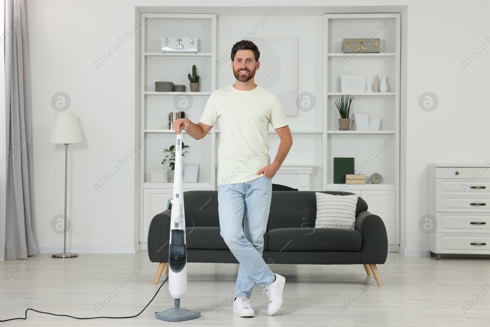 Photo of Happy man with steam mop at home