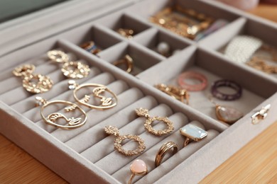 Elegant jewelry box with beautiful bijouterie on wooden table, closeup