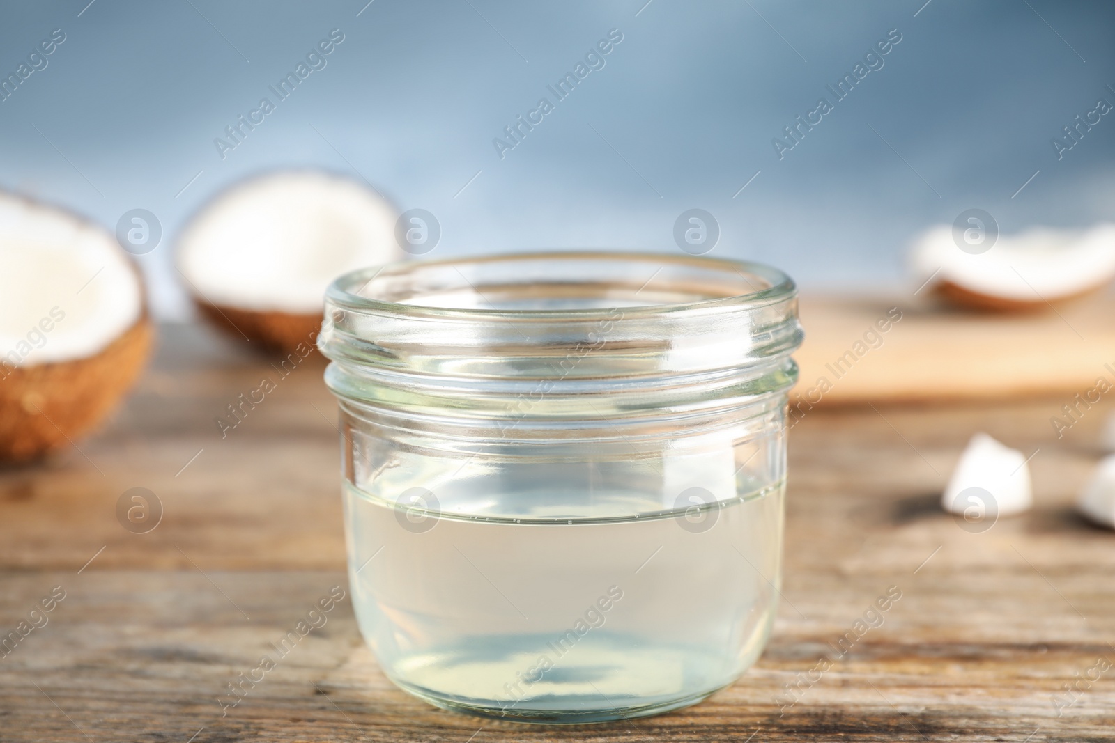 Photo of Coconut oil on wooden table, closeup view