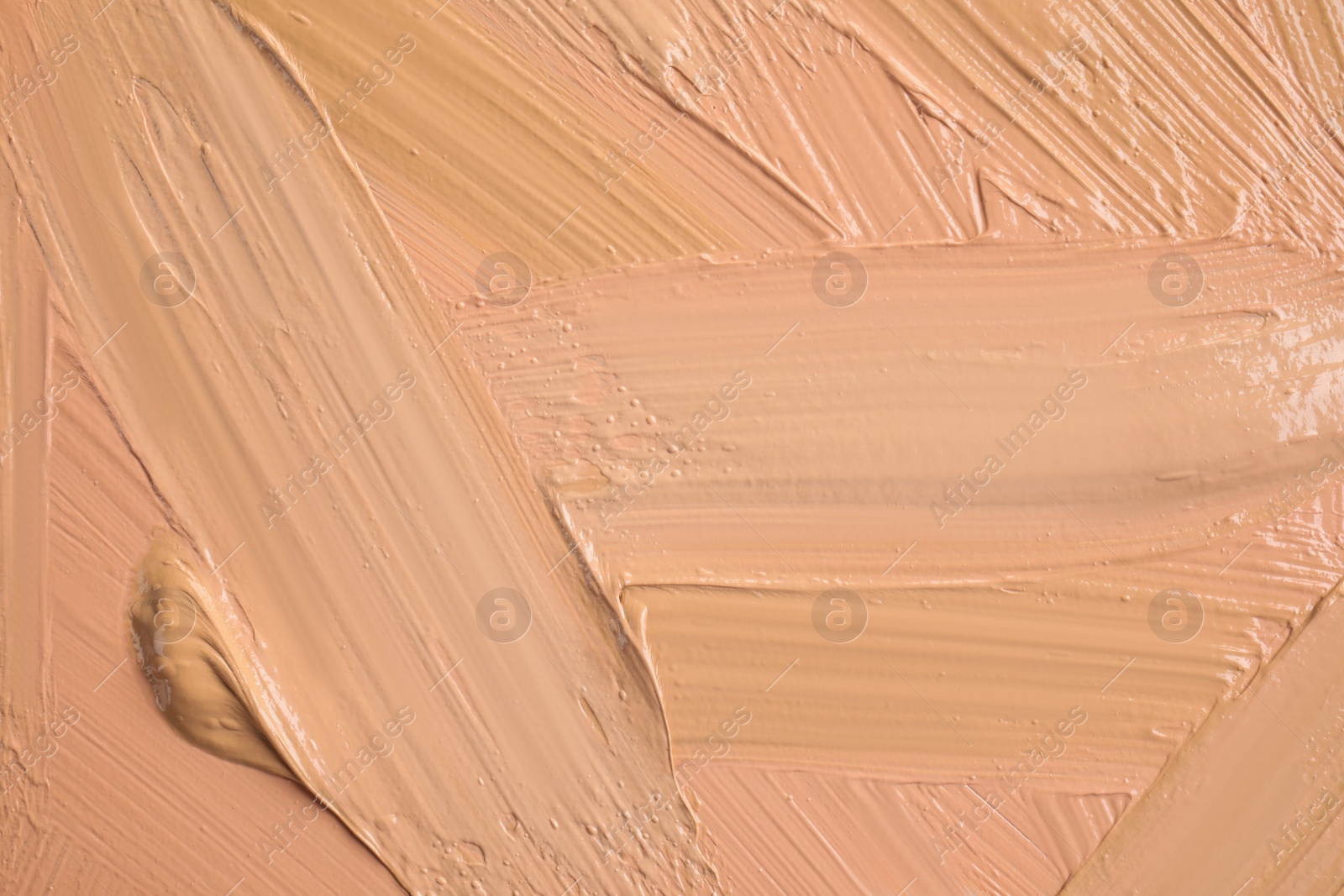 Photo of Samples of different foundation shades as background, top view