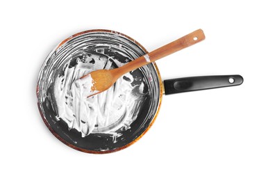 Photo of Dirty frying pan and wooden spatula on white background, top view