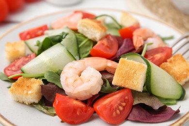 Photo of Tasty salad with croutons, tomato and shrimps on table, closeup