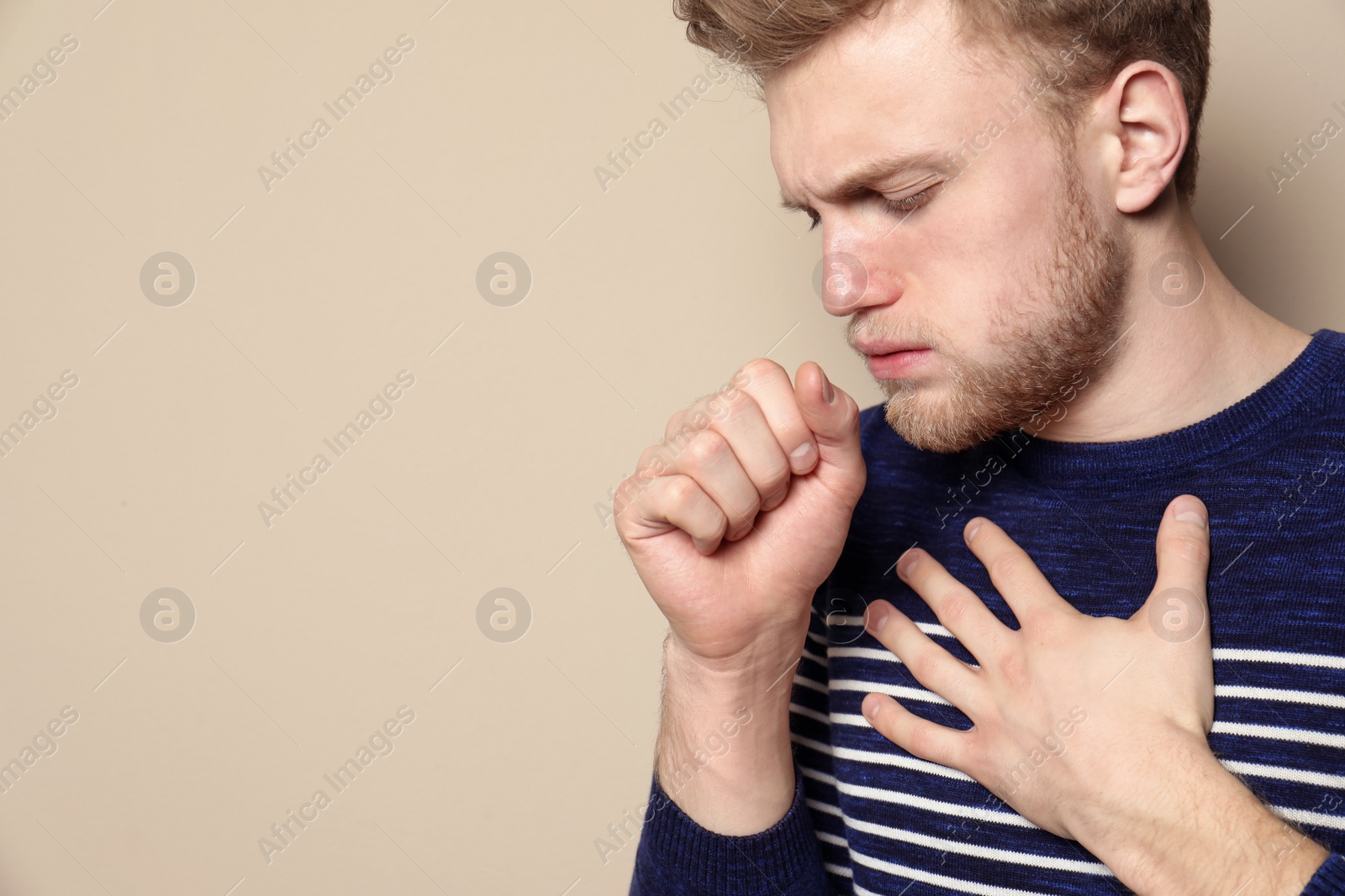 Photo of Handsome young man coughing against color background. Space for text