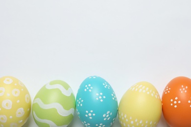 Colorful painted Easter eggs on white background, top view