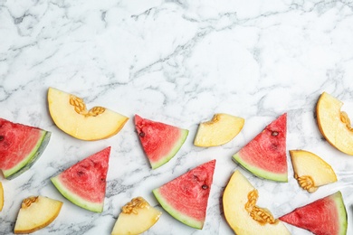 Photo of Flat lay composition with tasty sliced melon and watermelon on marble background. Space for text