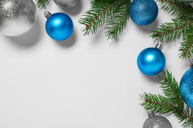 Christmas balls and fir tree branches on white background, flat lay. Space for text