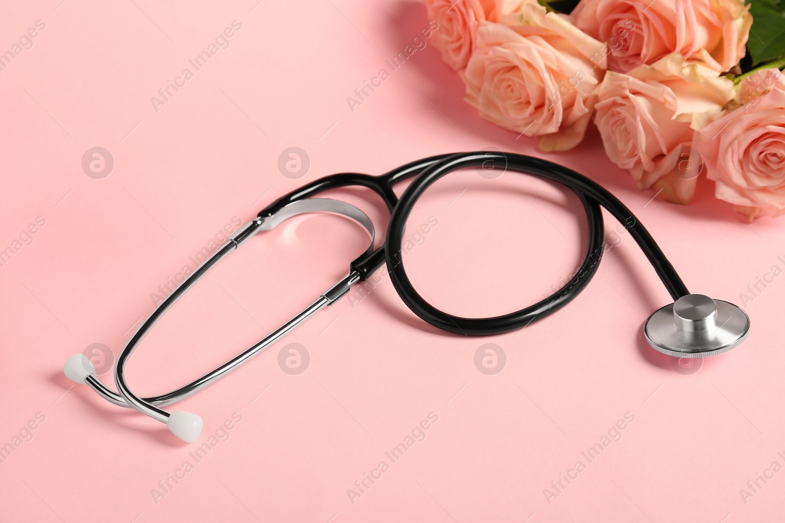 Photo of Stethoscope and flowers on pink background. Happy Doctor's Day