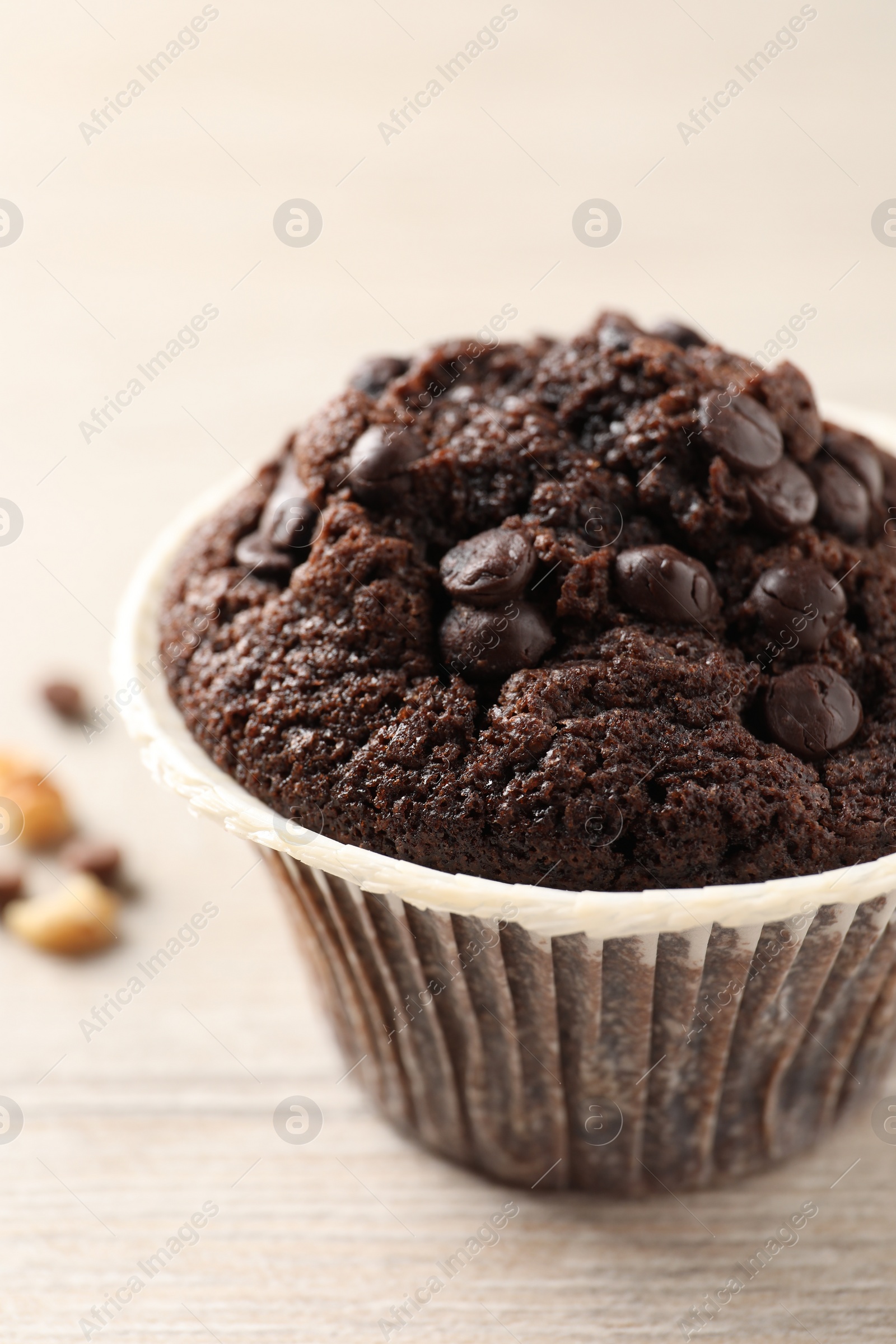 Photo of Delicious chocolate muffin on white wooden table, closeup