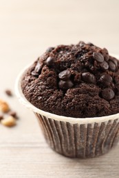 Delicious chocolate muffin on white wooden table, closeup