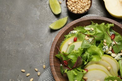 Photo of Fresh salad with pear and ingredients on grey table, flat lay. Space for text