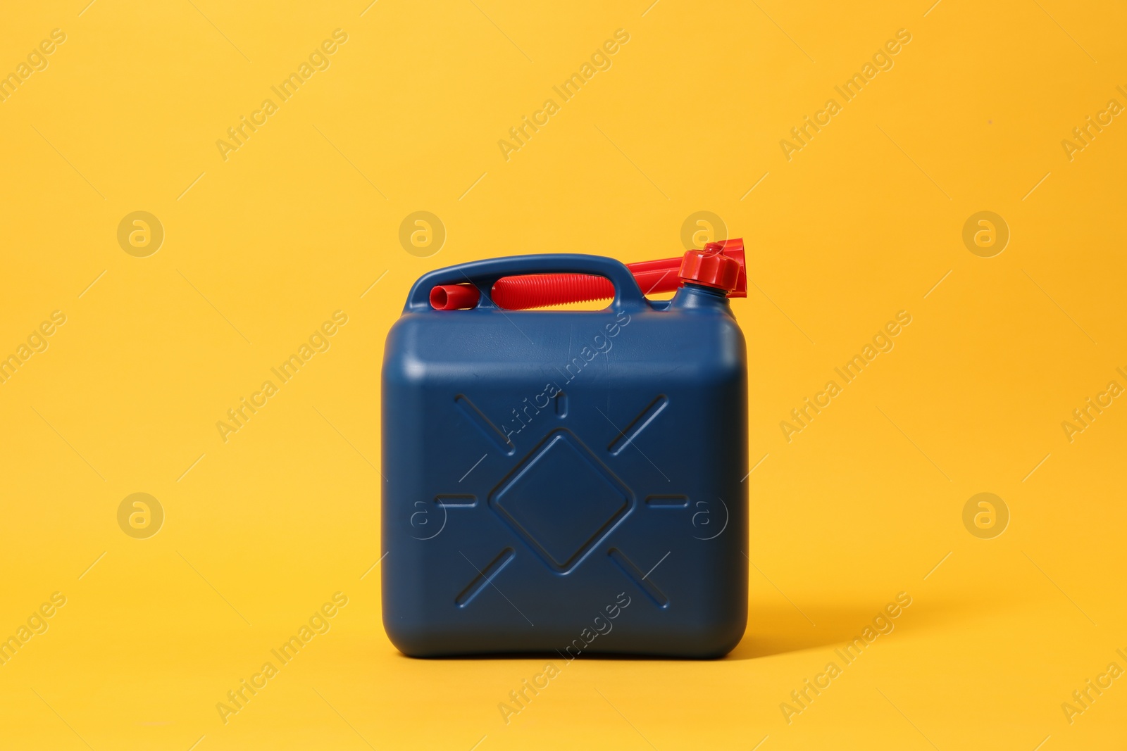 Photo of Blue plastic canister with tube on orange background