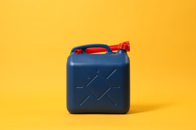 Photo of Blue plastic canister with tube on orange background