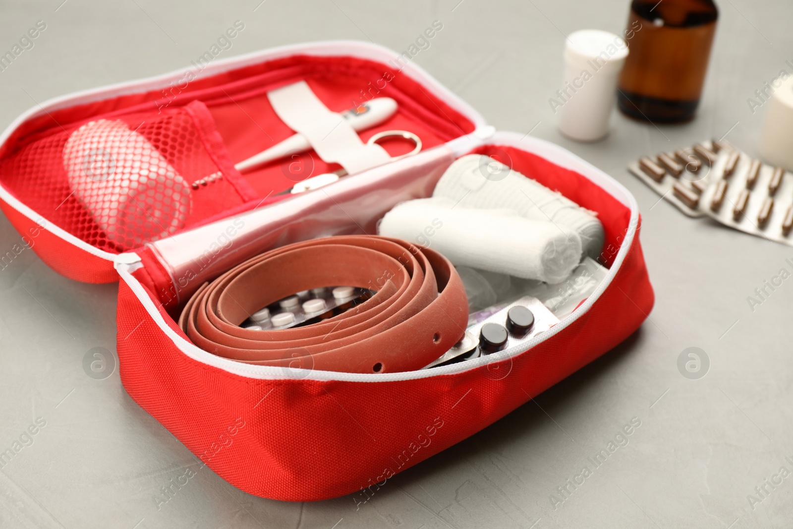 Photo of First aid kit on grey table, closeup