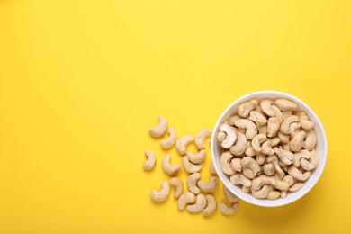 Tasty cashew nuts on yellow background, top view. Space for text