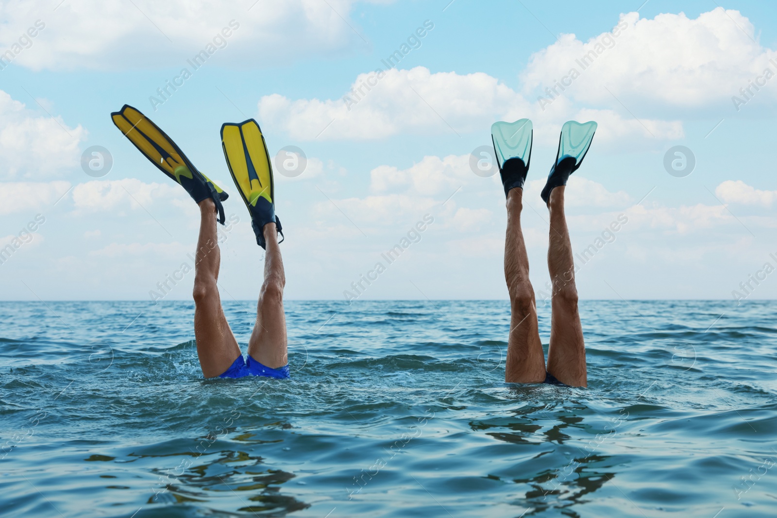 Photo of Men in flippers diving into sea water
