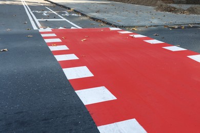 Photo of Bicycle lane painted red on crossroad outdoors