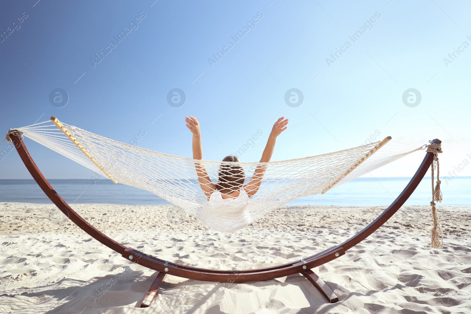 Photo of Young woman relaxing in hammock on beach