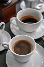 Cups of fresh aromatic coffee on grey background