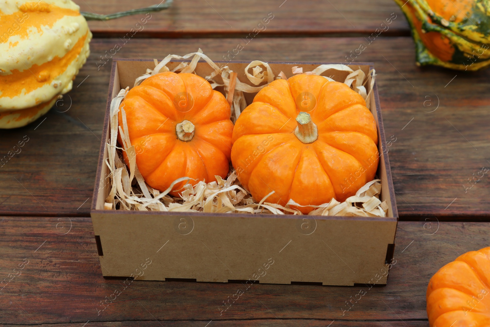 Photo of Crate and ripe pumpkins on wooden table