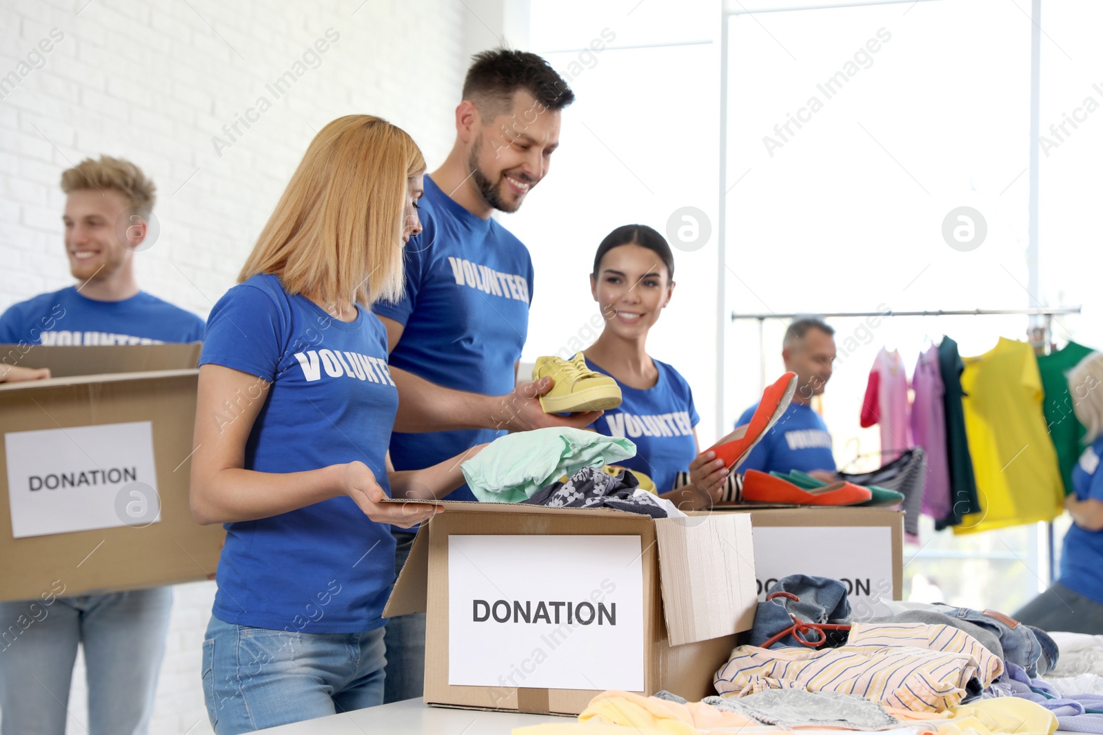 Photo of Team of volunteers collecting donations in boxes indoors