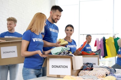 Team of volunteers collecting donations in boxes indoors