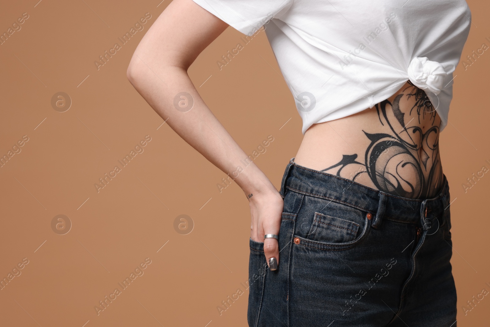 Photo of Woman with cool tattoos on beige background, closeup. Space for text