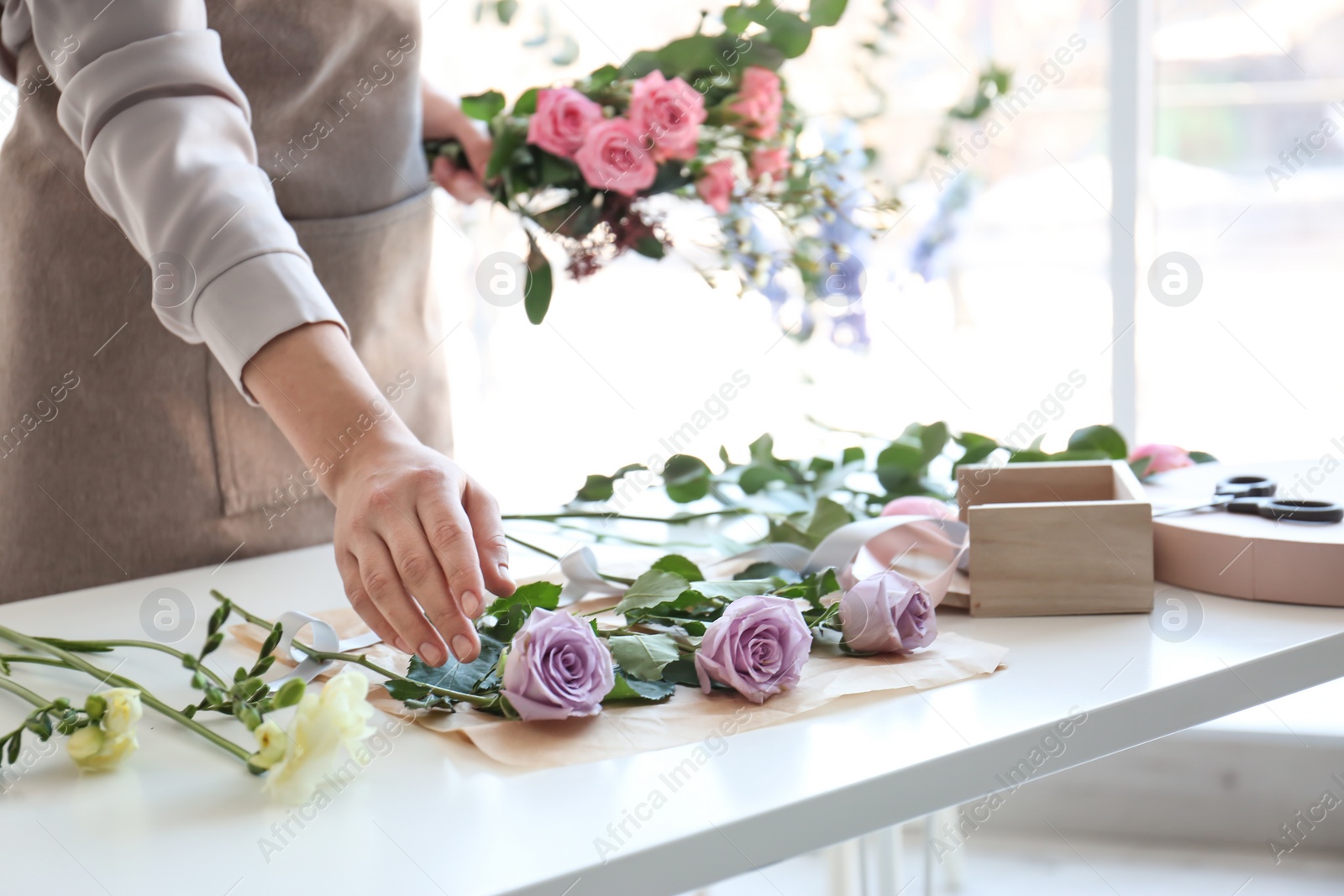 Photo of Female florist creating beautiful bouquet at table