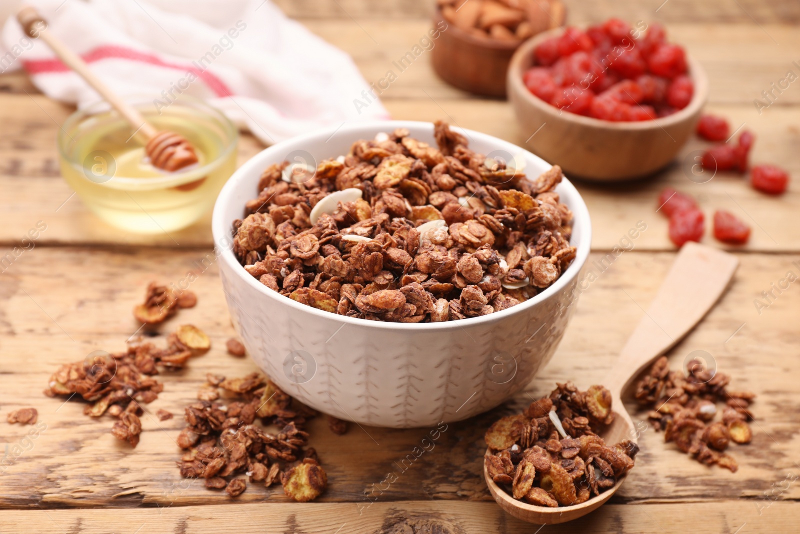 Photo of Tasty granola served with nuts and dry fruits on wooden table