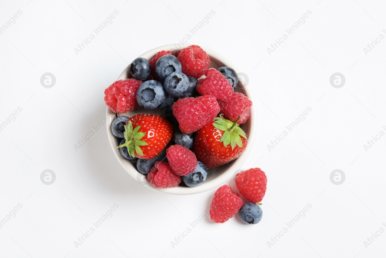 Photo of Bowl with raspberries, strawberries and blueberries on white background