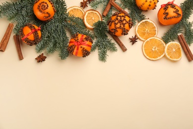 Photo of Flat lay composition with pomander balls made of fresh tangerines on beige background. Space for text