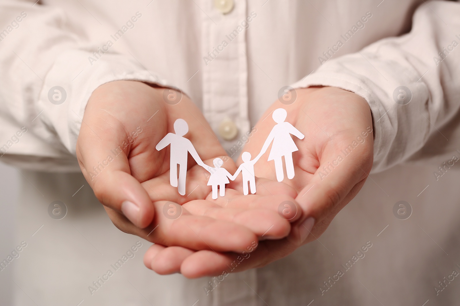 Photo of Man holding paper family figures, closeup. Insurance concept